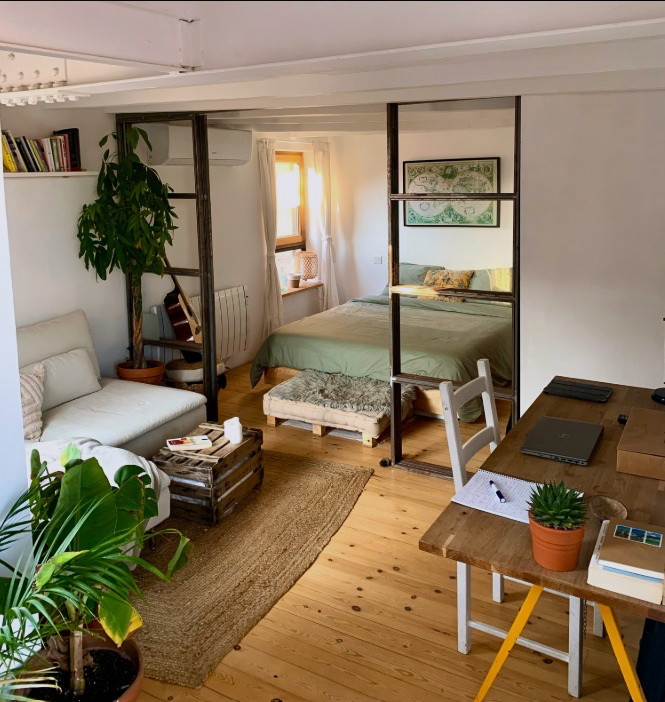 Pablo's home — a light loft with plants, a sofa and a low bed